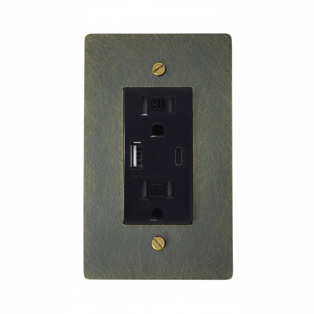 Aged bronze wall outlet cover with black electrical outlet on a white background