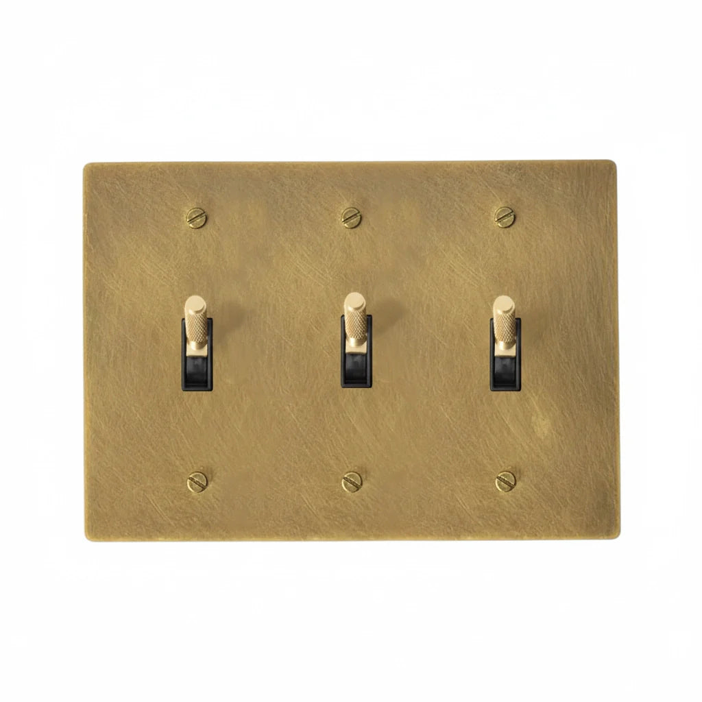 3-gang knurled toggle light switch plate in antique brass, hand-brushed, front view