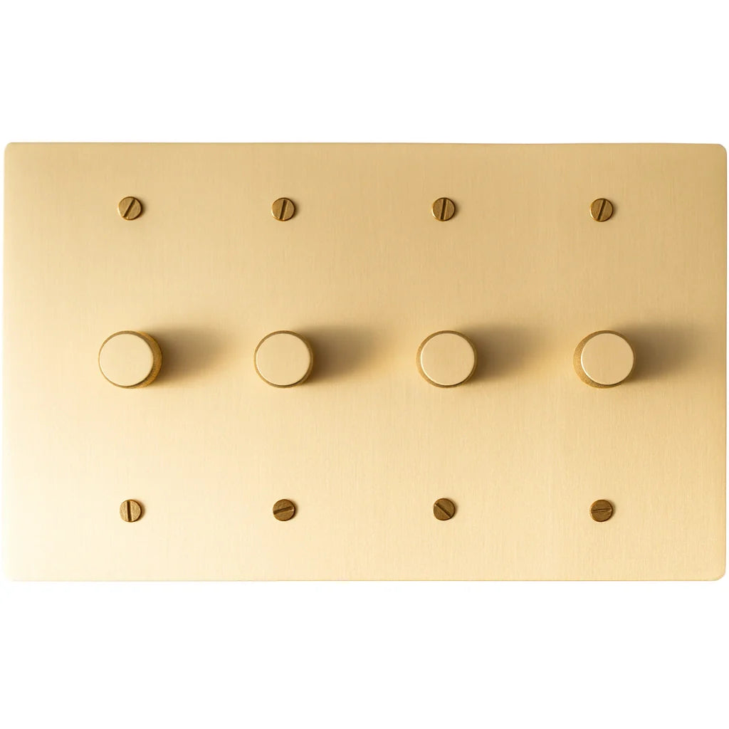 Four gang brushed brass dimmer light switch with rotary control knobs on rectangular plate.
