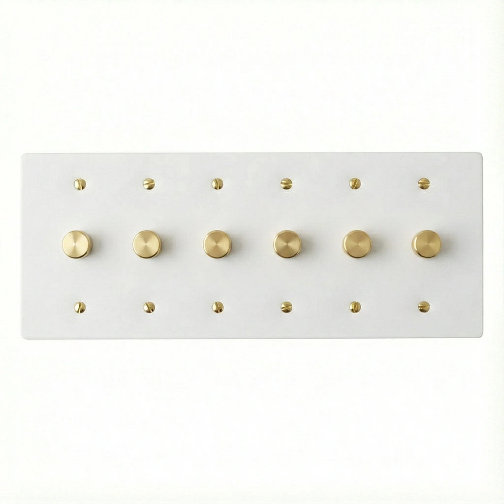 White 6 gang brass dimmer wall plate with gold screws on a white background