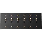 Close-up of knurled toggles on matte black 6-gang switch plate