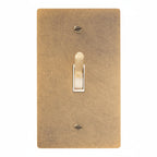Antique brass light switch cover with a single toggle on a white background