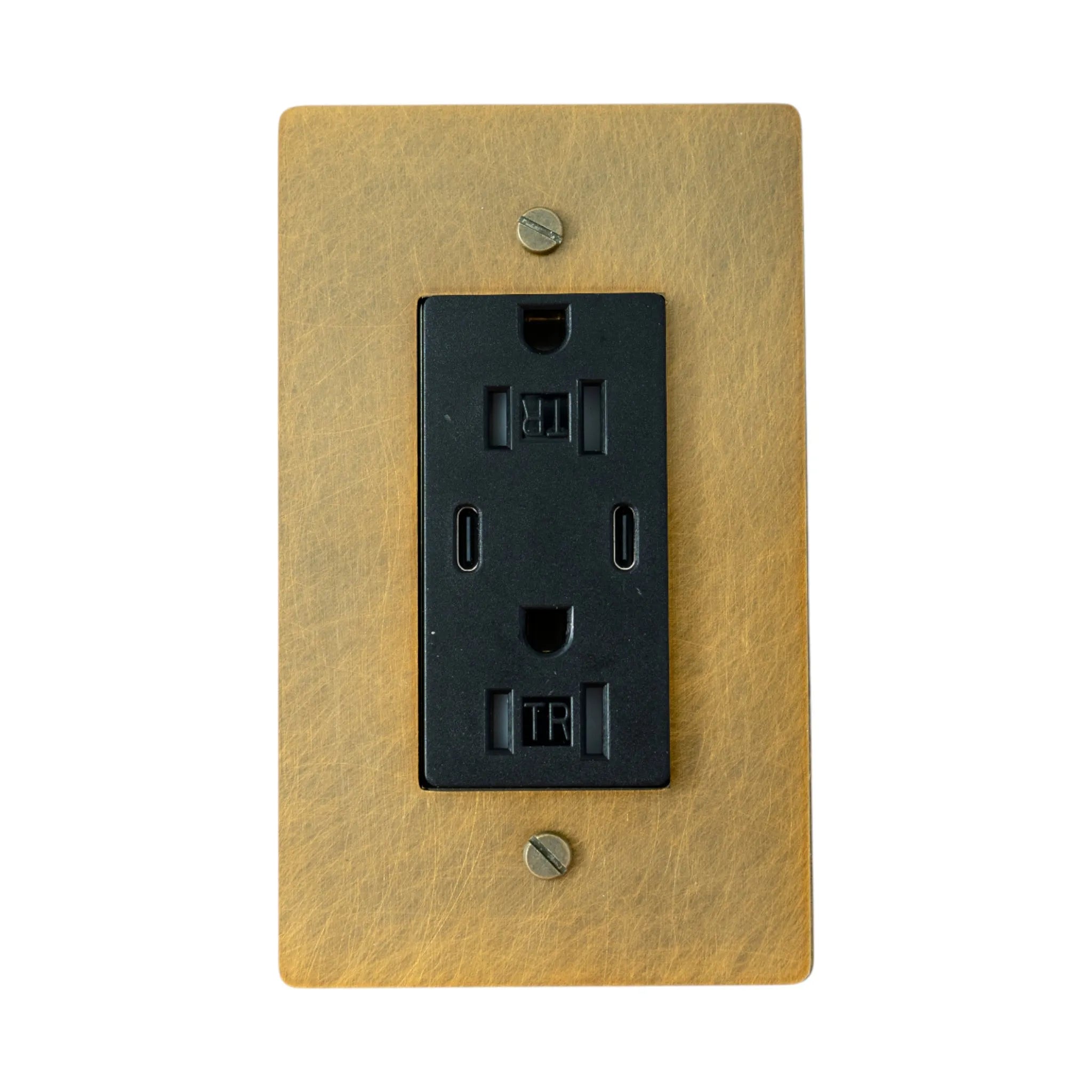 black electrical outlet on a antique brushed brass wall plate with screws