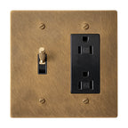 Brass wall plate with a switch and outlet on a white background