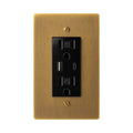 Antique brushed brass wall plate with black electrical outlet on a white background