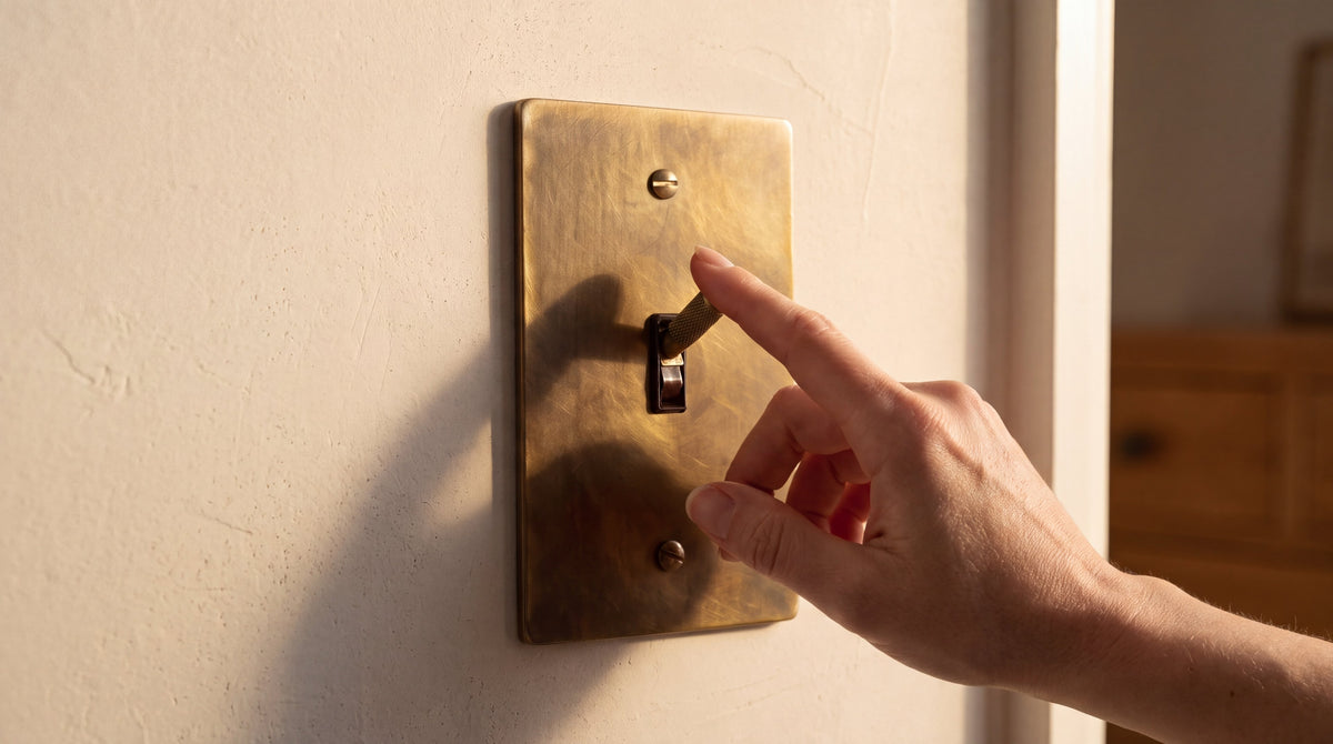 1-Gang Solid Brass Knurled Toggle Light Switch in Unlacquered Antique Brass being used by hand
