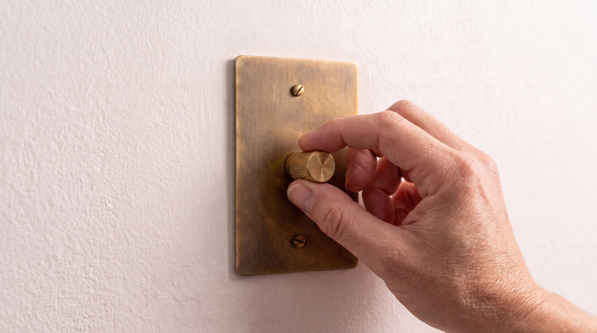 Solid Brass Low Voltage LED Dimmer in Unlacquered Antique Brass being used by hand