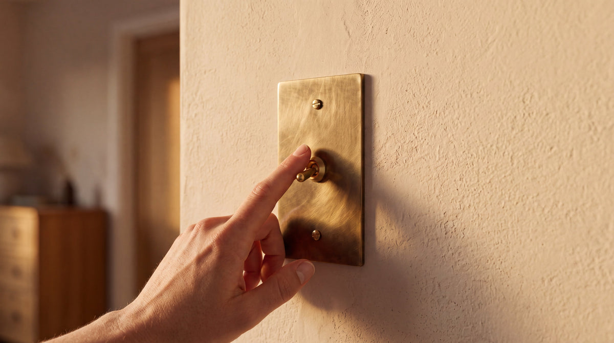 1-Gang Solid Brass Retro Toggle Light Switch in Unlacquered Antique Brass being used by hand